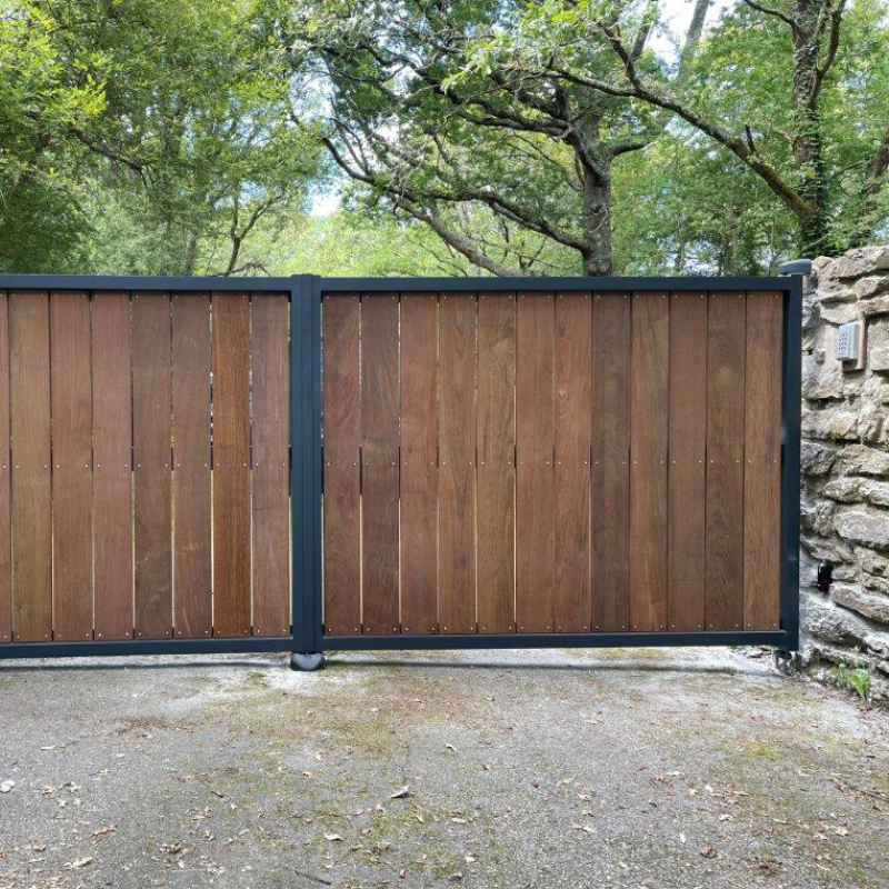 Portail en bois entouré de nature.